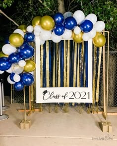 a photo frame with balloons and streamers in the shape of a sign that reads class of 2021