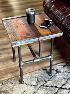 a table with a cell phone on it next to a couch and a cup of coffee