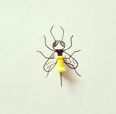 a yellow and black insect on a white wall