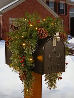 a mailbox decorated with pine cones and lights