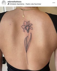 a woman's back with a flower tattoo on it