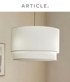 a white lamp hanging from the ceiling in a living room with text overlaying it