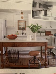 a kitchen with white cabinets and an island in the middle, surrounded by stools