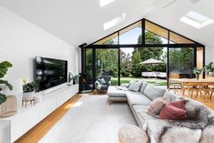 a living room with a couch, television and dining table in it's center