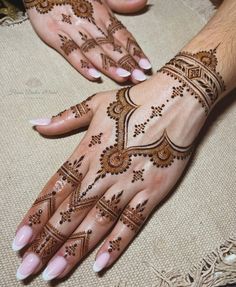 two hands with henna tattoos on them