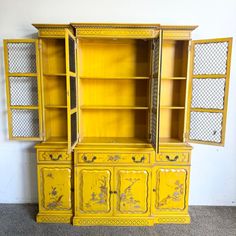 an old yellow painted china cabinet with two doors and one door open to the side