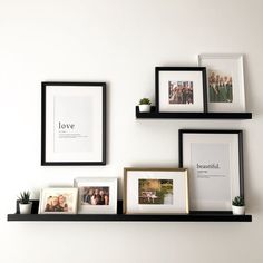 three black shelves with pictures and frames on them