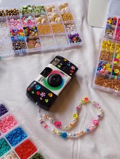 a camera sitting on top of a white table covered in lots of beads and beads