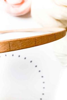 a close up of a wooden object on a table with yarn and scissors in the background