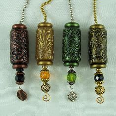 four different colored glass bead necklaces hanging from chains