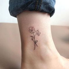 a small flower tattoo on the ankle