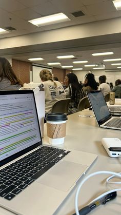 an open laptop computer sitting on top of a table next to a cup of coffee