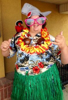 a man in a hula skirt and hat with two birds on his shoulder