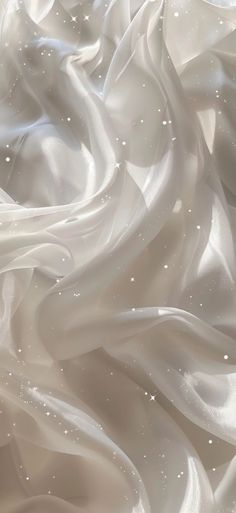 an abstract photo of white fabric with small dots on the top and bottom, as if it were blowing in the wind