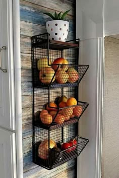 three wire baskets filled with fruit on top of a wall