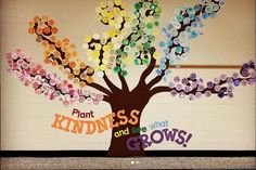 a bulletin board with the words plant kindness and see what grows on it in front of a tree