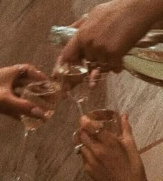 several people are holding wine glasses in their hands and toasting them with each other