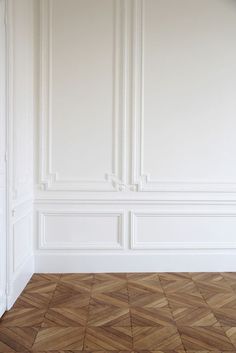 an empty room with wood flooring and white wall paneling on the walls is shown