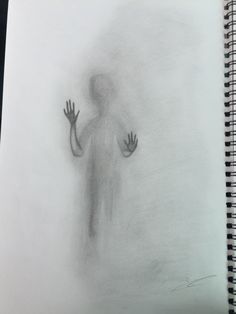 a drawing of a person with their hands out in front of the camera, on top of a spiral notebook