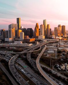 an aerial view of a city with many freeways in the foreground and cars on the other side