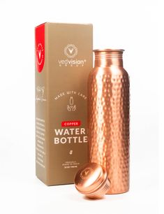 a copper colored water bottle next to a cardboard box