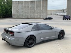 a silver sports car parked in front of a building