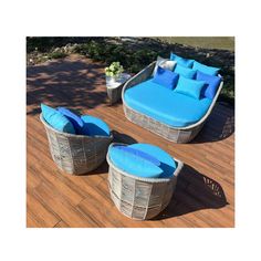 three wicker lounge chairs with blue cushions on a wooden deck next to a potted plant