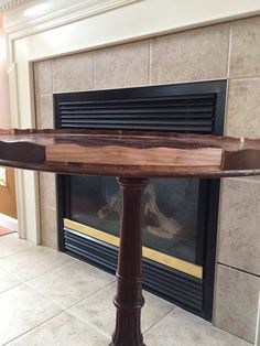 a wooden table sitting in front of a fireplace with a fire place on top of it