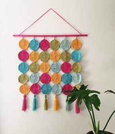 a wall hanging made out of crocheted circles and tassels