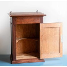 an open wooden cabinet on a blue surface