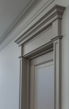 an empty room with white walls and molding on the trim around the door frame