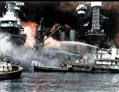 two boats are in the water near a large ship with fire coming out of it