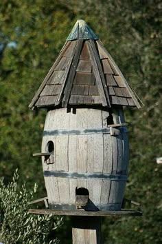 a wooden bird house with two birds perched on it