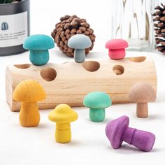 wooden toy mushrooms sitting on top of a table next to pine cones