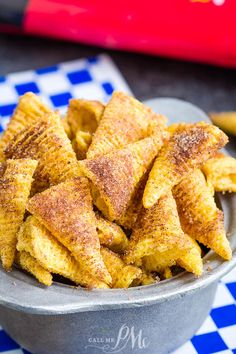 a bowl filled with fried food sitting on top of a checkered table cloth