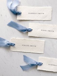 three blue ribbons tied to each other with name tags on the top and bottom of them