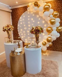 two white and gold vases with flowers on them in front of a balloon arch