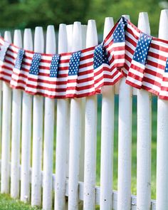 an american flag on a white picket fence