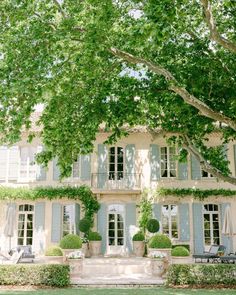 a large white house with blue shutters and windows