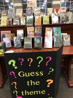 a sign that says guess the theme? on it in front of bookshelves