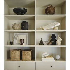 the shelves have baskets, vases and other items on them in white painted shelving