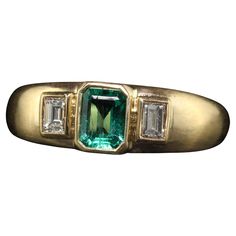 Beautiful Vintage Retro French 18K Yellow Gold Colombian Emerald Diamond Three Stone Ring. This gorgeous vintage French retro three stone ring is crafted in 18k yellow gold. The center holds a natural Colombian emerald and has two beautiful old cut diamond baguettes on the sides. The ring sits low on the finger and is in great condition. Item #R1882 Metal: 18K Yellow Gold Weight: 4.8 Grams  Size: 6 Emerald: Approximately .40 cts Side Diamonds: Approximately .25 ct Color: H Clarity: VS2 Measureme Vintage Ring Emerald, Emerald Engagement Ring Unique, Vintage Emerald Engagement Ring, Diamond Three Stone Ring, French Retro, Retro Ring, Gold Ring Designs, Three Stone Ring, Colombian Emeralds