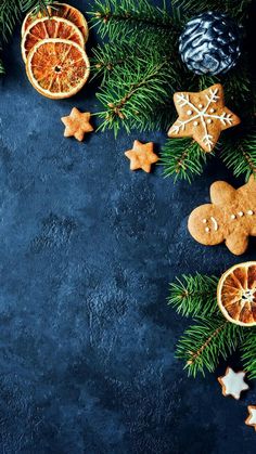 christmas cookies, orange slices and star decorations on a blue background with space for text