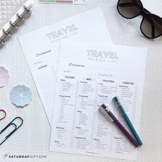 the contents of a travel planner laid out on a table with sunglasses, pens and paper clips