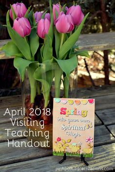 pink tulips are in a vase with a greeting card