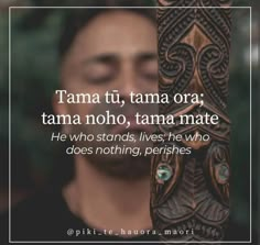 a man holding a wooden pole with a quote on it that reads, tama tu, tama ora tama noho, tama mate he who stands, lives, he who does nothing perishes