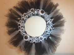 a black and white tulle wreath hanging on the wall in front of a mirror