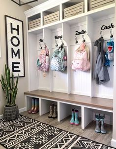 the entryway is decorated with white cubbys and coat racks filled with baby's clothes