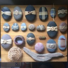 a wooden table topped with lots of rocks covered in different types of ribbons and bows