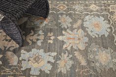 an area rug with flowers on it and a chair next to it in the background